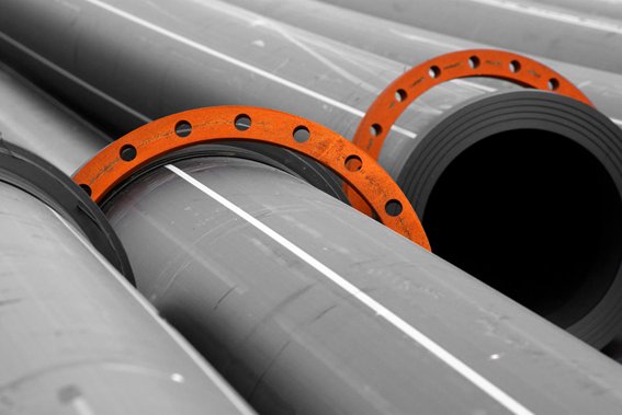 Large-diameter HDPE pipes with steel backing rings ready for installation.
